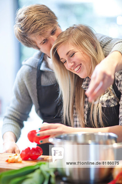 Affectionate young couple preparing meal