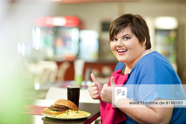 Junge Frau im Café mit ungesundem Essen