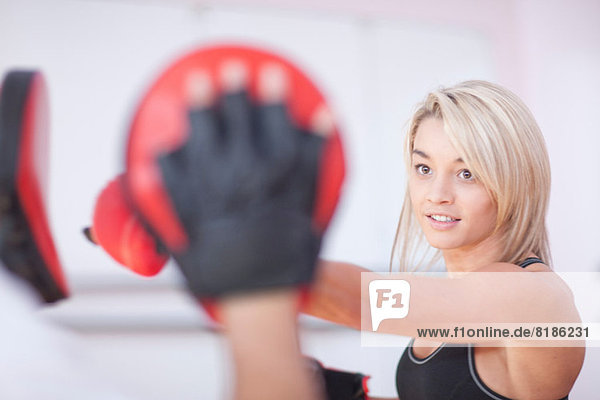 Junge Frau beim Boxen im Fitnessstudio