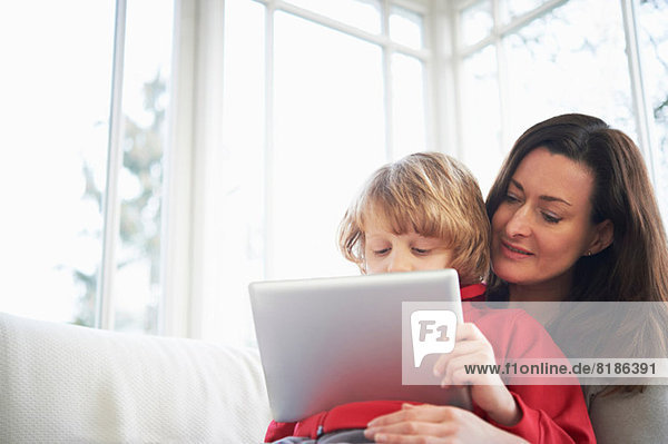 Mutter und Sohn auf dem Sofa mit digitalem Tablett