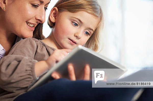 Mutter und Tochter mit digitaler Tablette