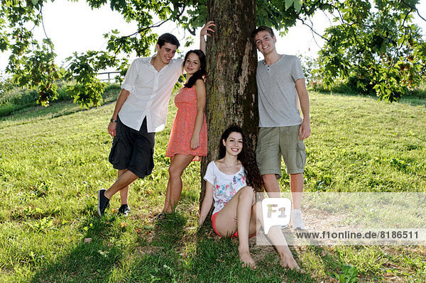 Portrait of young adults next to a tree