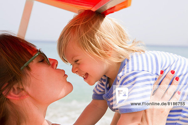 Mutter küsst Baby am Strand