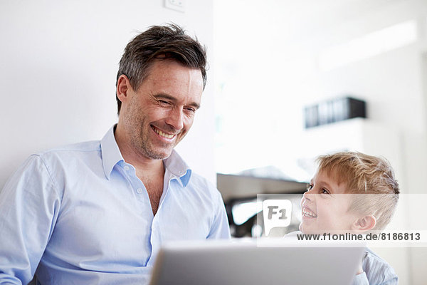 Mann mit Laptop  Sohn beobachtet