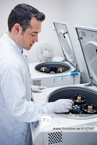 Man putting vials into centrifuge