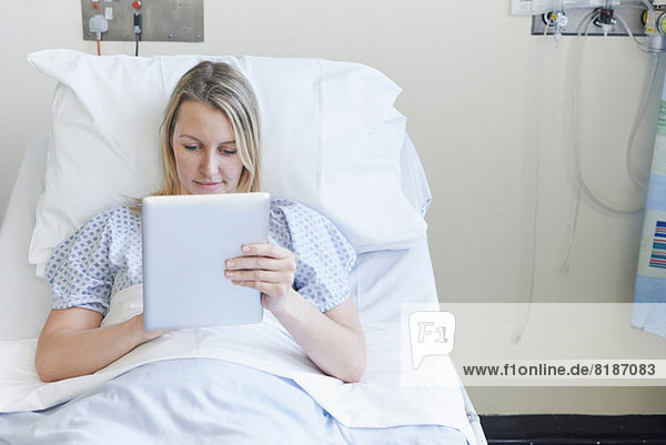 Patient auf dem Krankenhausbett liegend mit digitalem Tablett
