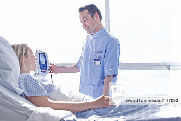 Krankenschwester  die den Blutdruck des Patienten nimmt
