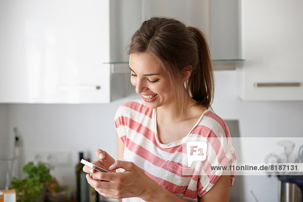 Frau lächelt und benutzt Handy