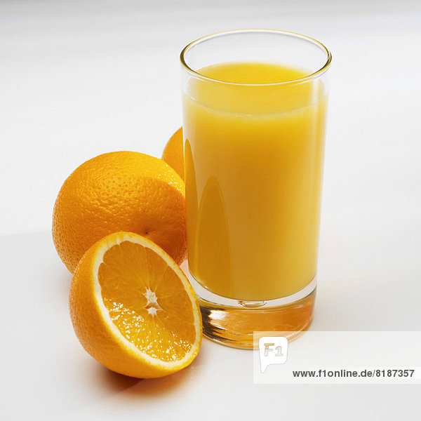 Glas Orangensaft mit frischen Orangen