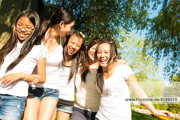 Fünf Mädchen in weißen T-Shirts lachend