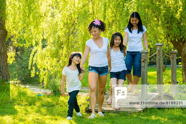 Frau und drei Mädchen auf Holzsteg im Park