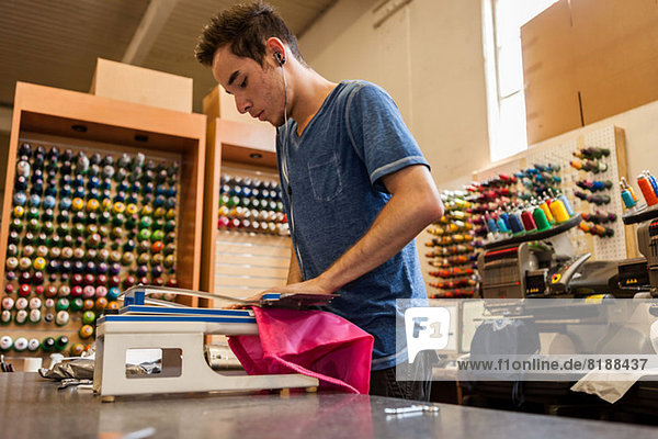 Arbeiterin mit Stickmaschine in der T-Shirt-Druckerei