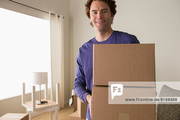 Portrait of mature man holding cardboard boxes