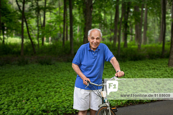 Älterer Mann mit Fahrrad und Lächeln  Porträt