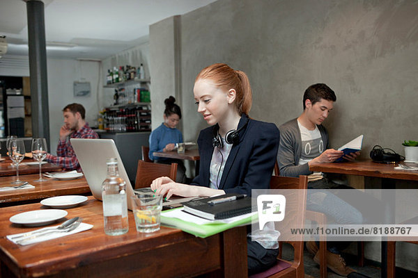 Young woman using laptop in cafe