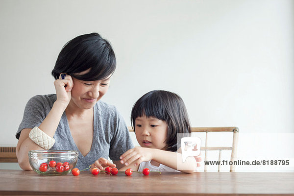 Mother and daughter counting cherries