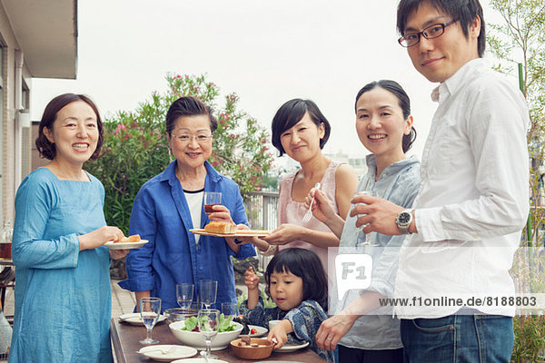 Three generation family eating outdoors  portrait