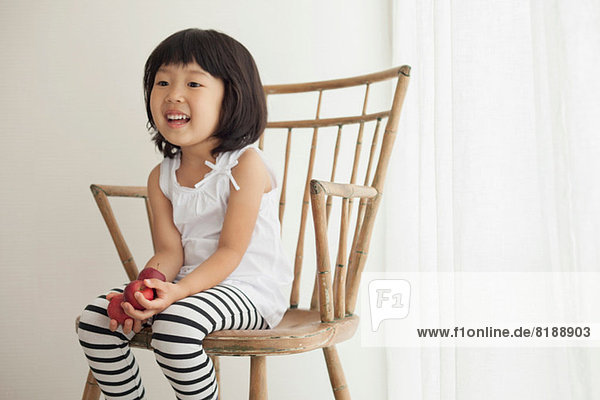 Girl sitting on wooden chair  portrait