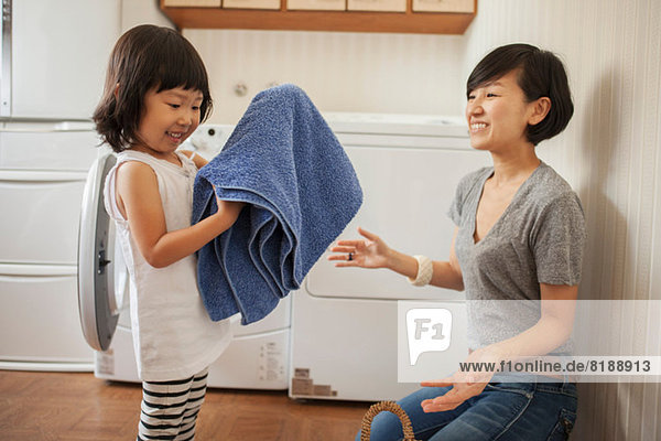 Mother and daughter  girl folding towel