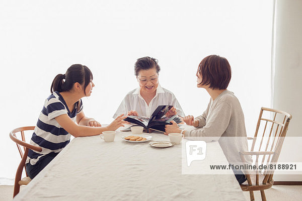 Three generation family looking at photograph album
