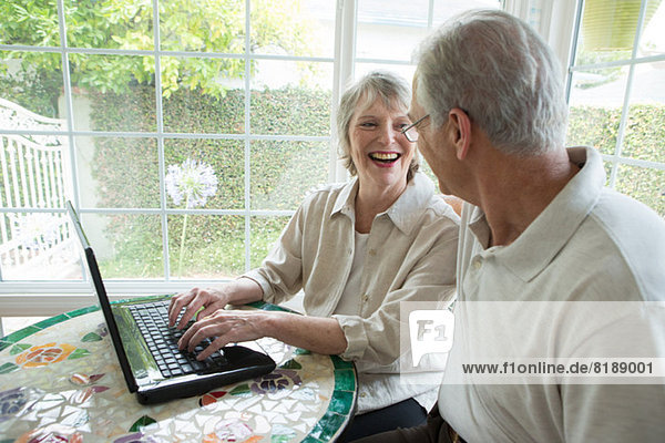 Senior Paar mit Laptop im Wintergarten