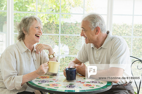 Senior couple at table in conservatory