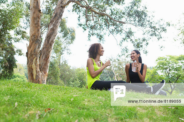 Mid adult and young woman relaxing in park