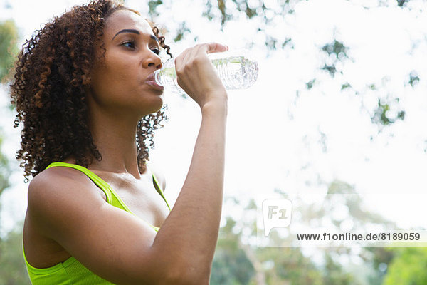 Mid adult woman drinking from water bottle