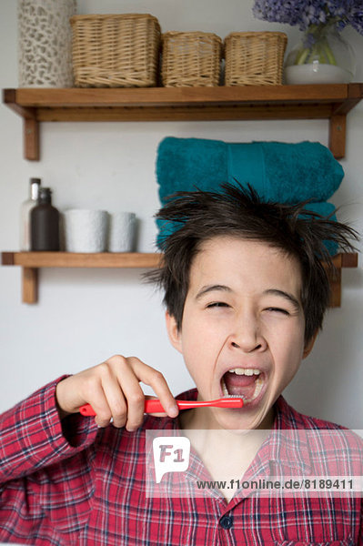 Boy yawning and brushing teeth  portrait