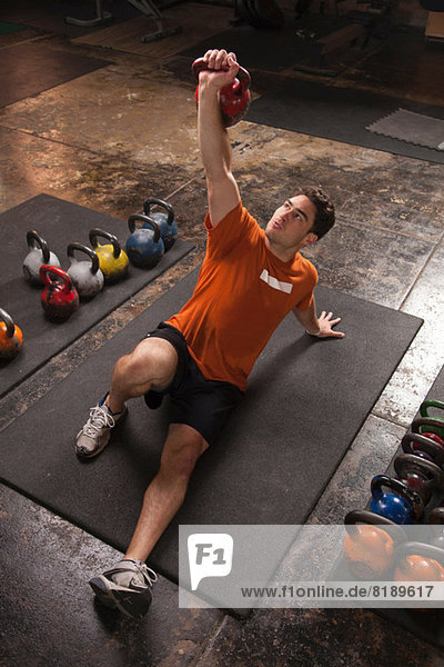 Bodybuilder lifting kettlebell in gym