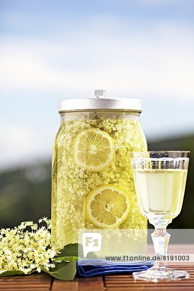 Selbstgemachter Holunderblütensaft mit Zitronenscheiben in einem Einmachglas