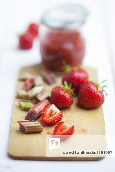 Erdbeeren  Rhabarber und Erdbeer-Rhabarber-Marmelade auf Holzbrett