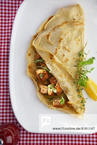 Pancake filled with fried cod  avocado and fresh oregano