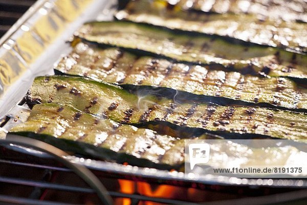Zucchinistreifen in Aluschale auf Grill