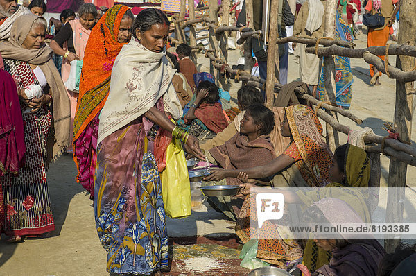 Bettler sitzen in einer Reihe während der Kumbha Mela