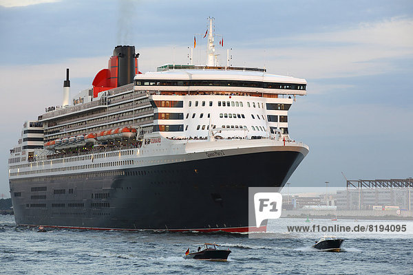 Cruise ship  MS Queen Mary 2  departing Hamburg harbour on the Elbe River in the evening light