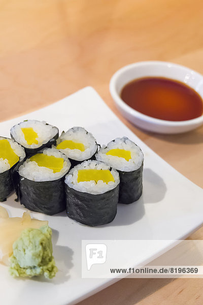 Sushi-Rollen mit gepflücktem Rettich in Reis auf Teller  Nahaufnahme