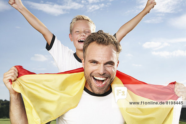Germany  Cologne  Father and son cheering in football outfit