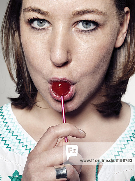 Portrait of Young woman licking lollipop  close up