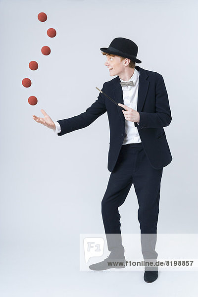 Young man showing magic with ball  smiling