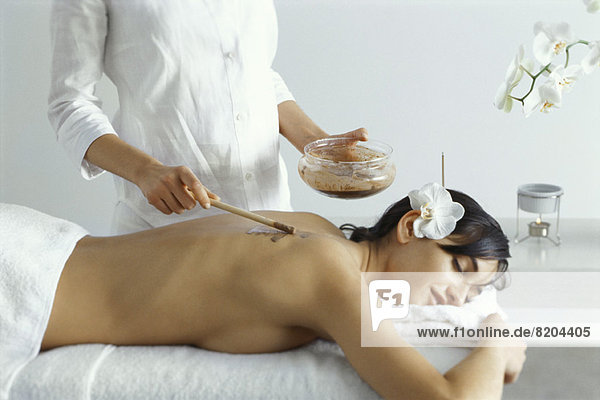 Woman lying on stomach  receiving spa treatment