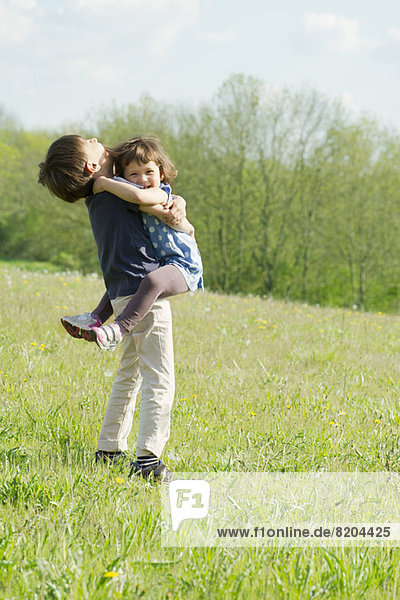 Young siblings embracing outdoors