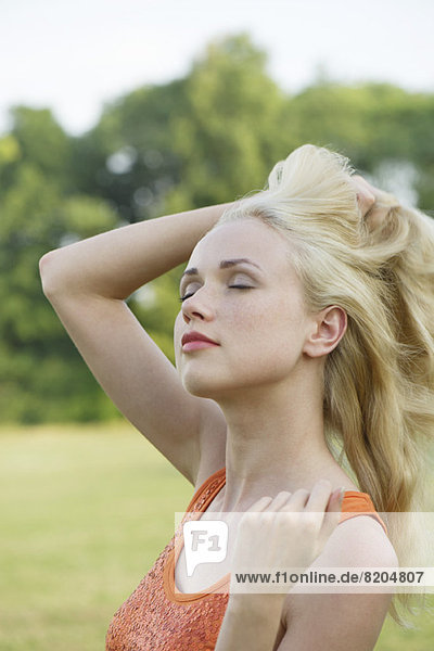 Young woman touseling her hair outdoors  portrait