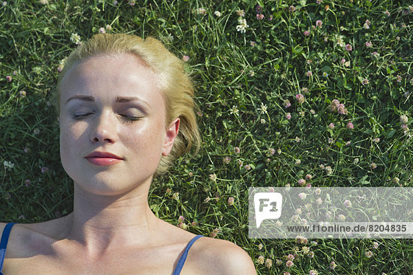 Young woman napping on grass  portrait
