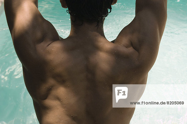 Man's muscular back  water in background
