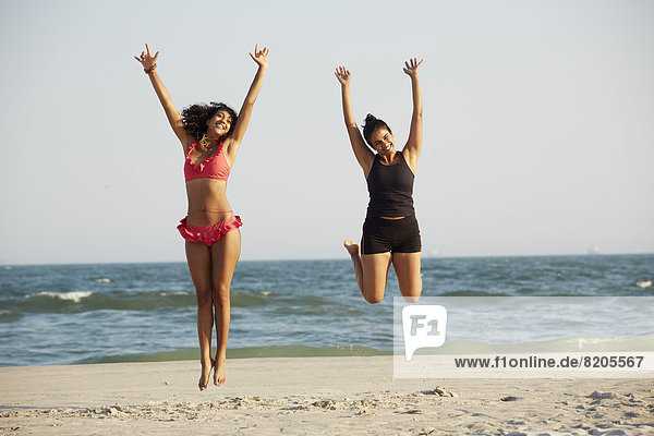 Women jumping for joy on beach