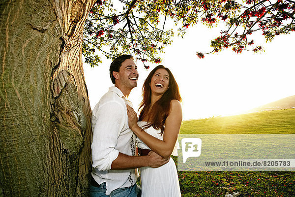 Couple hugging by tree in park
