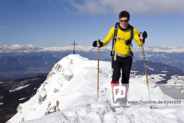 Winter hiker on the summit ridge of Jochgrimm  overlooking the summit of Weisshorn Mountain