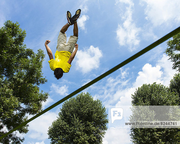 Young man jumping on a slackline