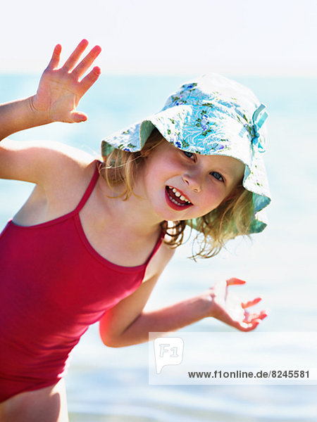 Portrait of small girl in red swimming suit and sun hat